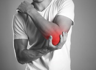 A man holding hands. Pain in the elbow. The hearth is highlighted in red. Close up. Isolated background