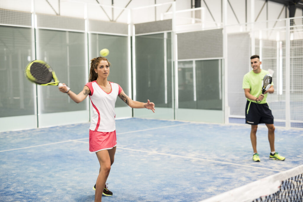 woman learning in paddle tennis class